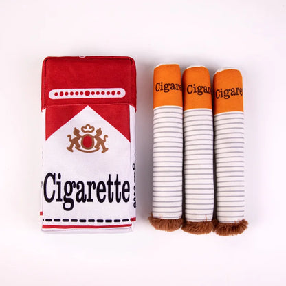 Paquet rouge et blanc en tissu et trois cigarettes en peluche pour chien alignées